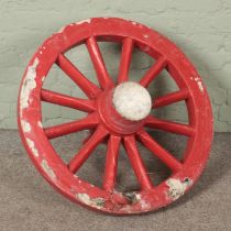 A large chunky wooden cart wheel. Diameter 86cm.