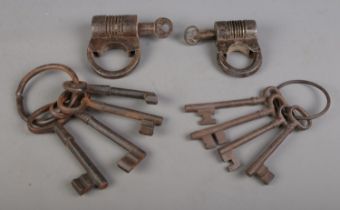 Two antique barrel shaped locks with screw keys, together with two rings of keys.