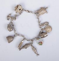 A vintage silver charm bracelet featuring eleven charms including turtle, barrels, fish, boat,