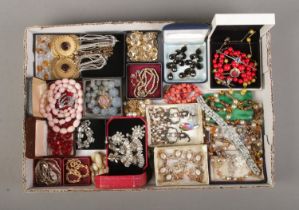 A tray of assorted vintage costume jewellery to include drop earrings, screw back earrings,