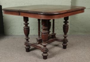 A French oak extending dining table with turned supports and shaped stretchers. Hx78cm Wx116cm