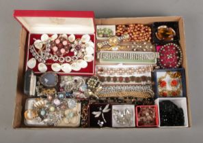 A tray of assorted vintage costume jewellery to include brooches, necklaces, bracelets, etc.