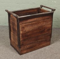 A panelled log basket featuring metal surround and handles. Approx. dimensions 62cm x 58cm x 34cm.