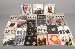 A quantity of The Beatles and The Rolling Stones single records.