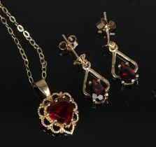 A 9ct gold jewellery suite to include pendant on chain and earrings all set with garnets. Total