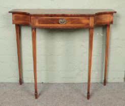 A walnut side table raised on tapering supports and spade feet.