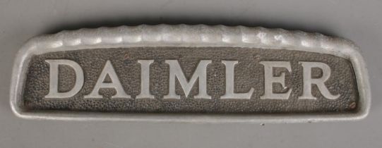 A vintage cast metal Daimler car badge. (11cm x 38.5cm)