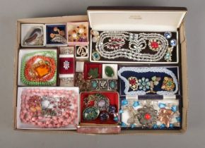 A tray of assorted vintage costume jewellery to include scarab beetle bangle, leaf pendant,