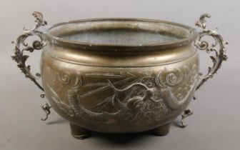 An late 19th/early 20th century Oriental brass vessel with dragon decoration. Height 20cm.