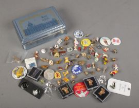 A tin of various pin badges.