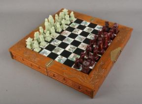 An oriental style folding chess set. One piece has head snapped off.