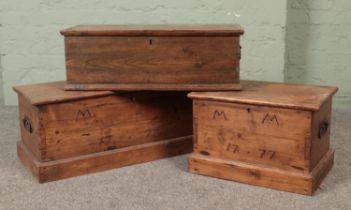 Three hinged top pine chests, two with MM 1777 branded to the front.