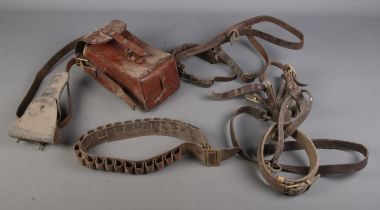 A box of leather items. Includes cartridge belt, gun holsters, satchel, etc.