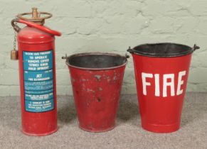 Two red painted buckets along with a J. Cowley and Son water jet fire extinguisher.