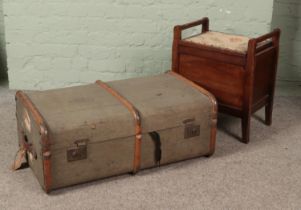 A vintage wood bound travel trunk along with a mahogany stool.