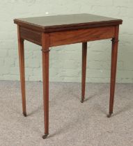 An Edwardian mahogany fold over games table.