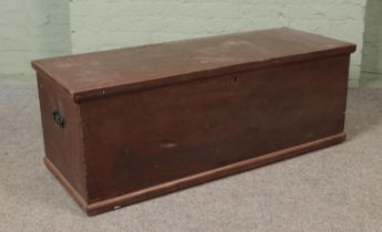 An early 20th century stained pine blanket box of long proportions with twin handles and interior