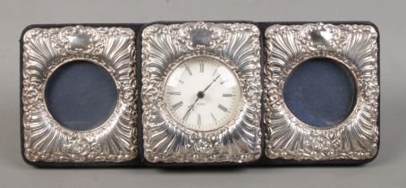 A silver mounted three section easel display stand, with central quartz clock flanked by two