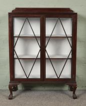 A mahogany glazed display cabinet raised on ball and claw feet. Hx123cm Wx90cm Dx32cm