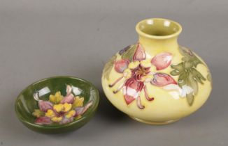 Two pieces of Moorcroft pottery decorated in the Columbine pattern. Includes vase of squat form