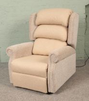 A 2023 model Repose electric riser/recliner armchair, with remote, in cream upholstered fabric.