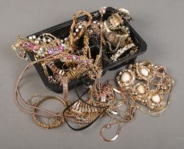 A tray of gold coloured jewellery, mainly necklaces and bracelets.