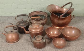 A good collection of copper wares to include coal scuttle, several teapots, graduated bowls, etc.