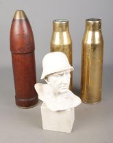 A collection of militaria to include pair of brass artillery shells, wooden artillery shell