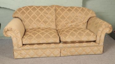 A three seat sofa with beige floral upholstery. Length: 224cm.