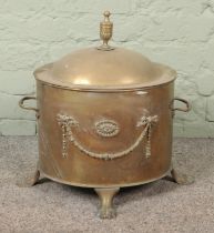 A brass lidded coal bucket/log bin with lion paw feet.