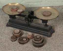A set of cast iron scales labelled Force with brass trays and several weights.
