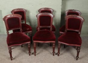 A set of six Victorian chairs with red upholstery.