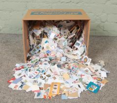 A box containing a good collection of loose Great British and world stamps. Approximately 4kg.