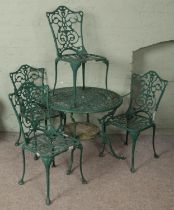 A painted metal garden table and four matching chairs. One chair missing an arm. Paint waring away.