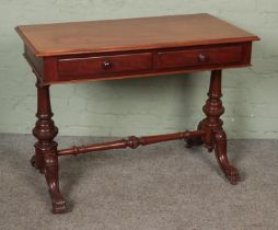 A mahogany writing table with turned supports and carved detail. Hx75cm Wx102cm Dx54cm