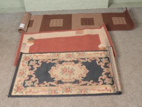 Three Belgian made wool rugs to include geometric stair runner and floral example.