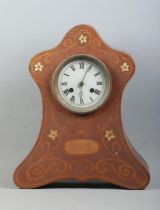 A mahogany cased mantle clock, with silvered dial featuring Roman Numeral markers and scrolled and