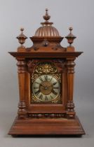 A German carved bracket clock, with fish scale detailing, reeded columns and turned finials.