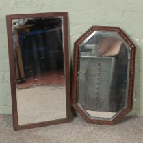 Two oak framed bevel edged wall mirrors including example featuring carved floral detail.