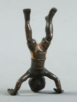 A miniature cold painted bronze sculpture of a boy doing a handstand. 4cm.