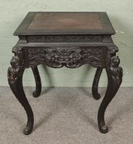 A large Chinese ebonised square table, profusely carved with drawer to either side