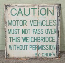 An enamel road sign reading "Caution Motor Vehicles Must Not Pass This Weighbridge Without