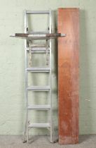 A folding wooden pasting table, together with a set of ABRU 'Step N Ladder' ladders and ladder