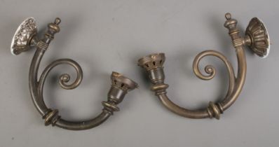 A pair of brass light fitting wall sconces with decorative curved design.