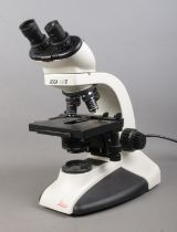 A Leica CM E binocular microscope, featuring 4X, 10X, 40X, 100X lenses. With branded protective dust