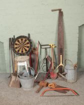 A collection of assorted tools and sporting equipment to include Holex dart board, saws, golf clubs,