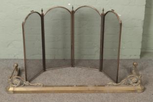 A brass extended fire fender along with brass fire screen.