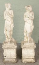 A pair of painted concrete statues on stands formed as semi nude maidens. (125cm) Split to ankles of