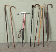 A collection of walking sticks and canes to include two silver mounted examples hallmarked (