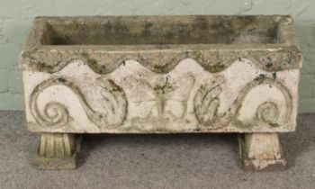 A rectangular concrete garden planter raised on stand. Decorated with butterfly and scrollwork. (